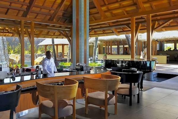 Bar im Trou aux Biches Beachcomber Golf Resort & Spa mit Blick auf einen Pool und Wasserfall.