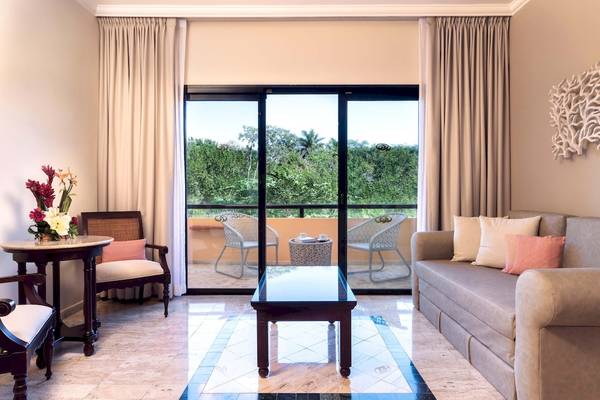 Wohnzimmer im Grand Palladium White Sand Resort & Spa mit großer Glastür und Blick auf den Garten