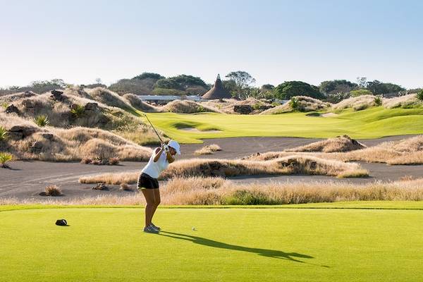Eine Frau spielt Golf auf dem Golfplatz im Trou aux Biches Beachcomber Golf Resort & Spa.
