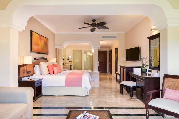 Luxuriöse Suite im Grand Palladium White Sand Resort mit Kingsize-Bett, Badewanne und moderner Einrichtung.