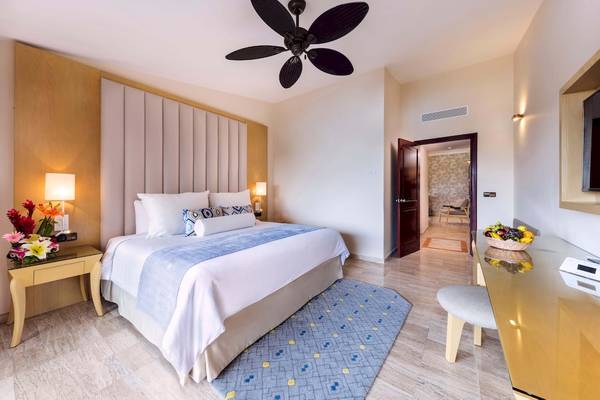 Schlafzimmer im Grand Palladium White Sand Resort & Spa mit Doppelbett, Nachttischen und Deckenventilator.
