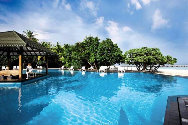 Außenpool des Adaaran Select Meedhupparu Hotels mit Blick auf den Strand und Palmen