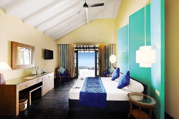 Hotelzimmer im Adaaran Select Meedhupparu mit Bett, Schreibtisch und Aussicht.