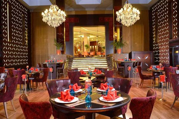Innenansicht des Restaurants im Pickalbatros White Beach Resort mit geräumigen Tischen, luxuriösen Stühlen und großen Kronleuchtern.
