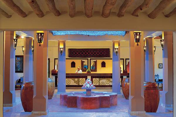 Innenansicht des Neptune Pwani Beach Resorts mit Rezeption und Brunnen.