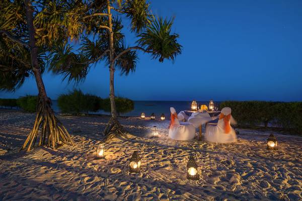 Neptune Pwani Beach Resort & Spa Stranddinner mit gedecktem Tisch und Laternen.