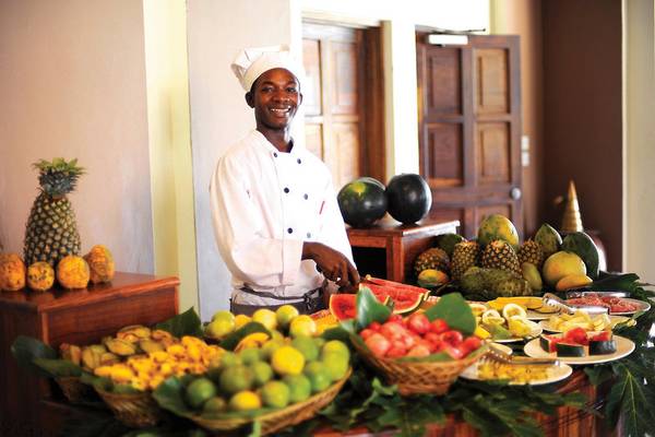 Koch im Neptune Pwani Beach Resort & Spa mit verschiedenen Früchten