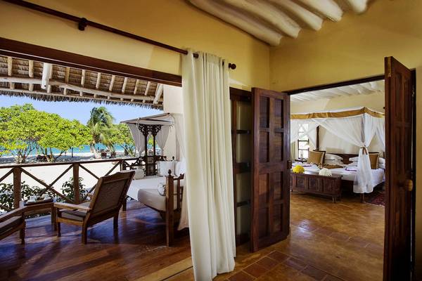 Innenansicht einer Strandsuite im Neptune Pwani Beach Resort & Spa mit Blick auf das Meer.