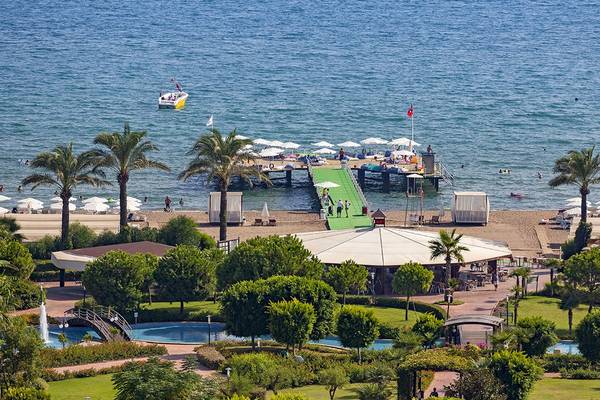 Wunderschoenes Resort am Meer mit Booten und Palmen