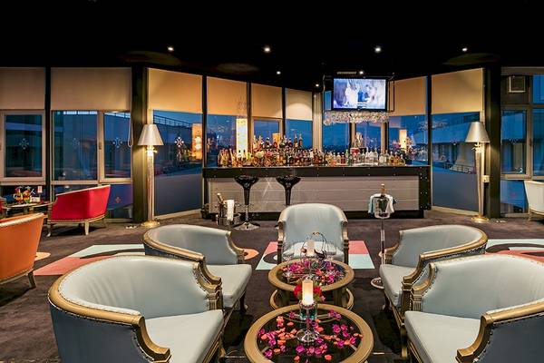 Lounge-Bereich im Miracle Resort mit Bar, Fernseher, Sesseln und Tisch mit Blumendekor.