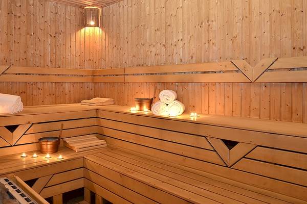 Saunabereich im Miracle Resort Hotel mit Holzbänken, Kerzen und Handtüchern