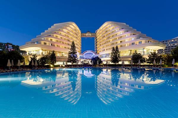 Miracle Resort im Abendlicht mit Swimmingpool und Hotelreflektion