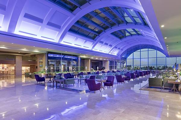 Einrichtung der Lobby im Miracle Resort mit violetten Beleuchtung und großen Fenstern.