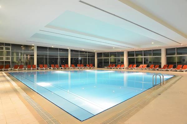 Wunderschöner Innenpool im Miracle Resort mit vielen roten Liegestühlen darum herum.