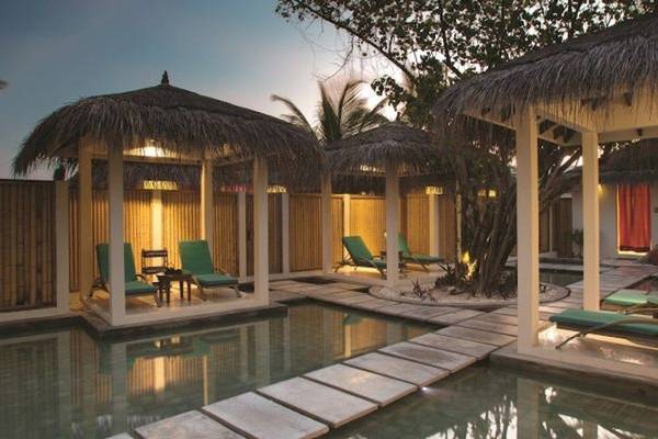Außenbereich des Oblu Nature Hengeli mit Swimmingpool und Lounge-Gebieten unter Strohdächern.