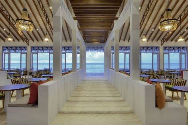 Innenbereich des OBLU Nature Helengeli Restaurants mit Blick auf das Meer und mehreren Tischen und Stühlen.