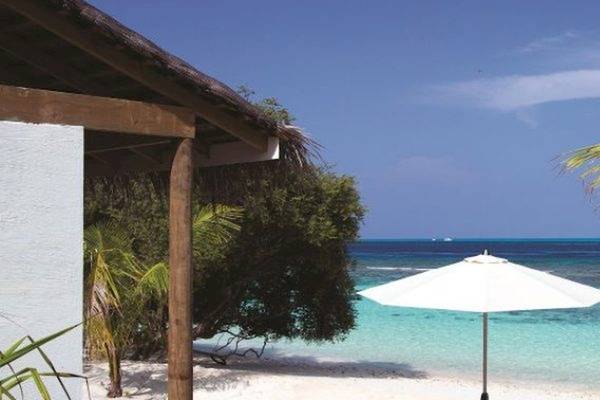 Strand des OBLU NATURE Helengeli Hotels mit weißem Sonnenschirm und Blick auf das Meer.