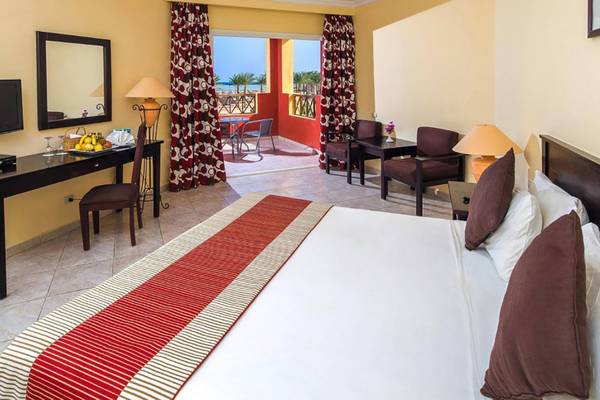 Innenansicht eines Hotelzimmers im Casa Mare Resort mit Bett, Tisch, Balkon und Ausblick.