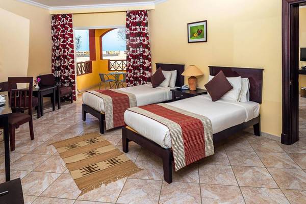 Doppelzimmer im Casa Mare Resort mit zwei Betten, Tisch, Stühlen und Balkon