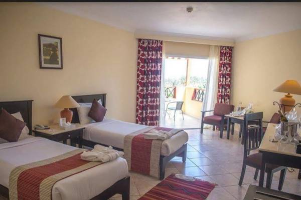 Doppelzimmer im Casa Mare Resort mit zwei Betten, Tisch, Stühlen und Balkon