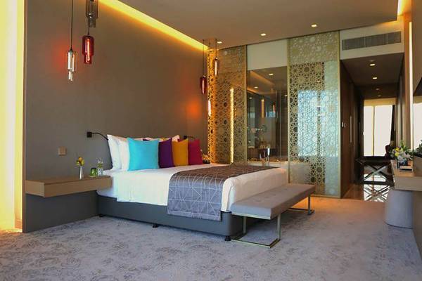 Hotelzimmer im Rixos Premium Dubai JBR mit großem Bett und bunten Kissen.