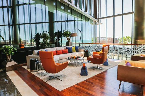 Lobby-Lounge-Bereich des Rixos Premium Dubai JBR mit modernen Möbeln und großer Fensterfront.