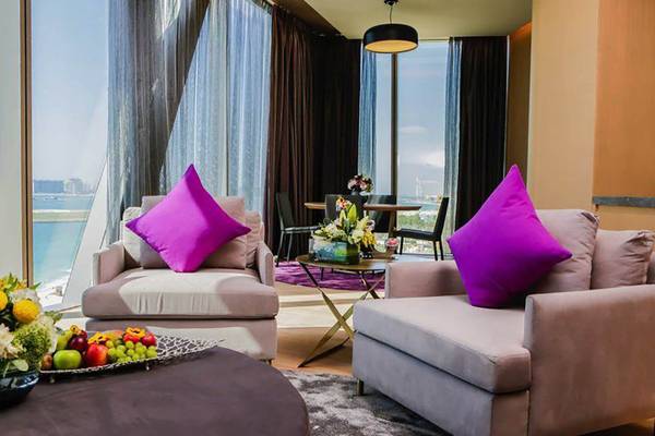 Hotellounge mit zwei Sesseln, Tisch, Früchten und Blick auf das Meer