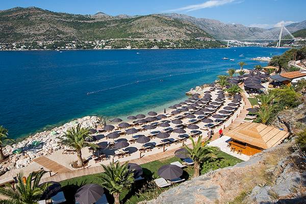 Luftaufnahme des Club Dubrovnik Sunny Hotel von Valamar mit vielen Sonnenschirmen am Strand