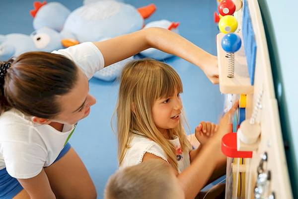 Eine Frau und zwei Kinder spielen im Club Dubrovnik Hotel von Valamar.