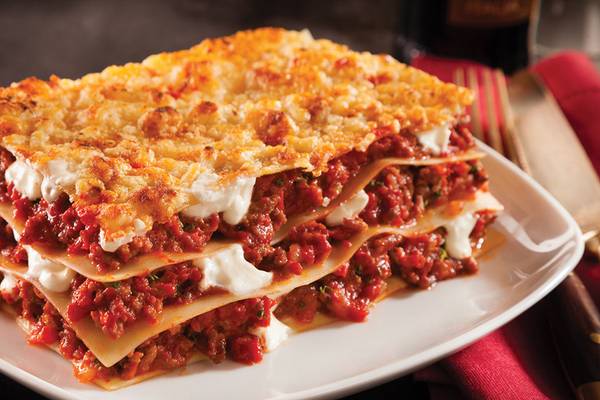 Eine Portion Lasagne mit Tomatensoße und Käse auf einem weißen Teller, serviert im Crystal Family Resort & Spa.