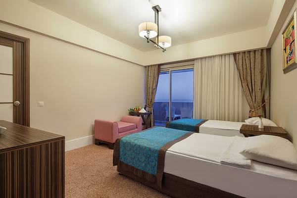 Zimmer im Crystal Family Resort & Spa mit zwei Betten, einem Stuhl und einem Fenster mit Aussicht.
