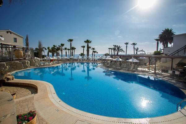 Außenpool des Louis Althea Beach Hotels mit Sonnenschirmen und Liegestühlen