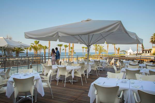 Terrasse des Louis Althea Beach Hotels mit Blick auf das Meer und Palmen