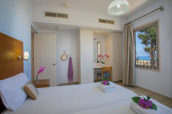 Schlafzimmer im Louis Althea Beach Hotel mit zwei Betten, Blick auf das Meer.