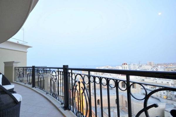 Aussicht von Balkon von AX The Palace Hotel mit zwei schwarzen Stühlen und schwarzer Balustrade.