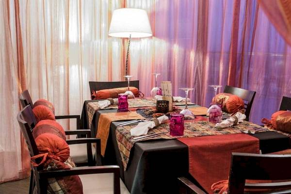 Das Esszimmer im AX The Palace Hotel mit Tisch, Stühlen und Tischdekoration.