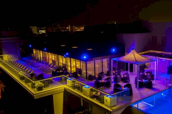 Nachtansicht der Dachterrasse des AX The Palace Hotels mit blauen Beleuchtung und Swimmingpool