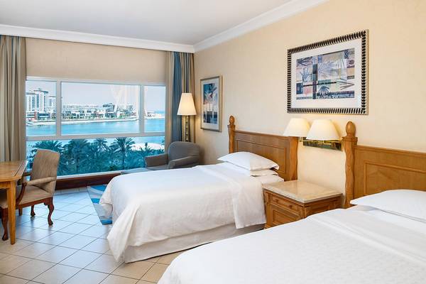 Doppelzimmer im Sheraton Jumeirah Beach Resort mit Blick auf die Stadt und das Meer.