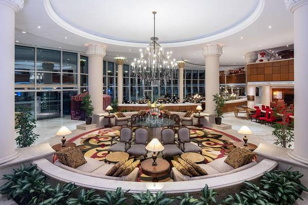 Lobby des Sheraton Jumeirah Beach Resorts mit großem Kronleuchter und gepolsterten Sitzbereichen.