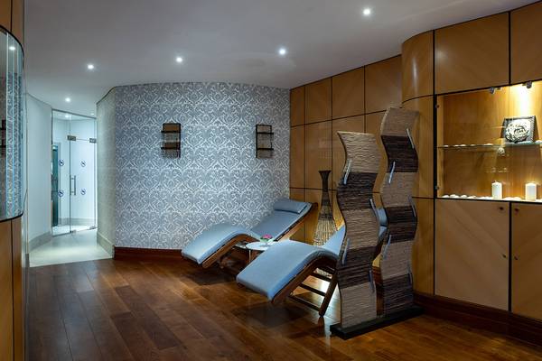 Innenbereich des Sheraton Jumeirah Beach Resorts mit Lounge-Liegestühlen und gemusterten Wänden.
