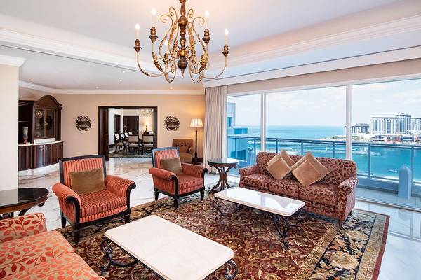 Wohnzimmer im Sheraton Jumeirah Beach Resort mit Blick auf das Meer und eine Stadtlandschaft.