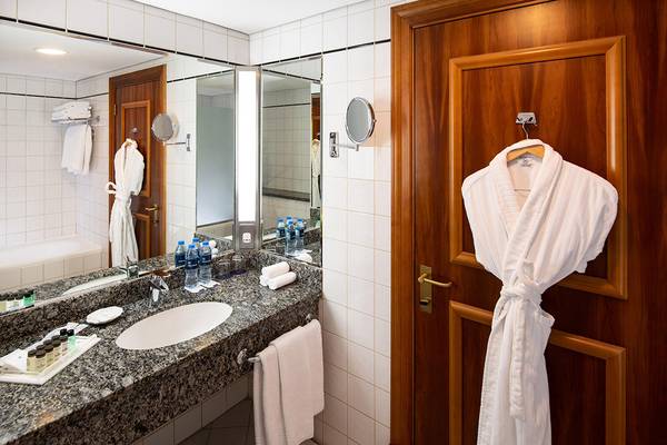 Badezimmer im Sheraton Jumeirah Beach Resort mit Waschbecken, Spiegel und Bademantel