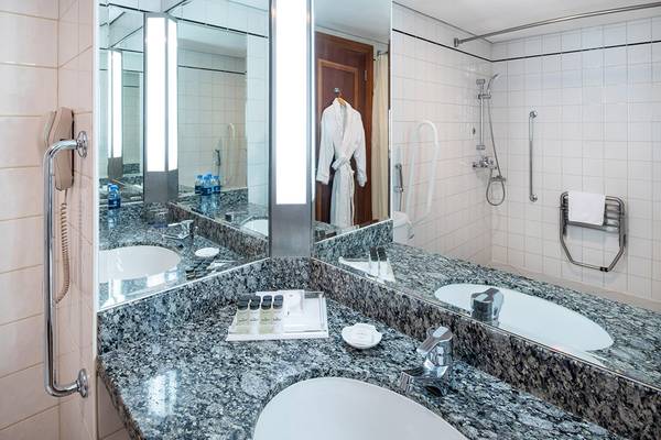 Badezimmer im Sheraton Jumeirah Beach Resort mit Granit-Fußboden und großen Spiegeln.