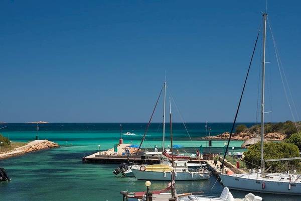Foto von der Marina des Hotel Ollastu Resort mit mehreren Booten und türkisfarbenem Wasser.