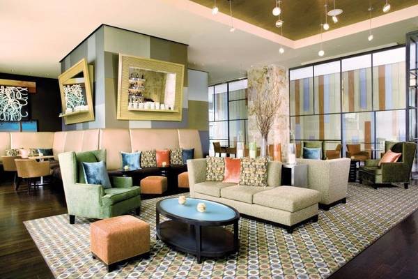 Lobby im Westin New York am Times Square mit Sofas, Sesseln und einem großen Tisch.