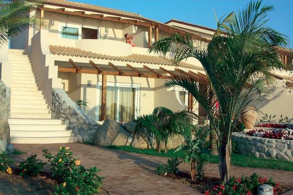Außenansicht des Cala di Volpe Hotels mit Treppe, Balkon und Palmen