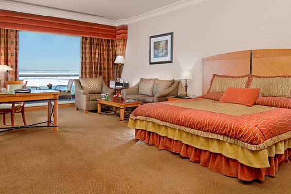 Suite im Al Raha Beach Hotel mit Meerblick, Bett, Schreibtisch und Sofas.
