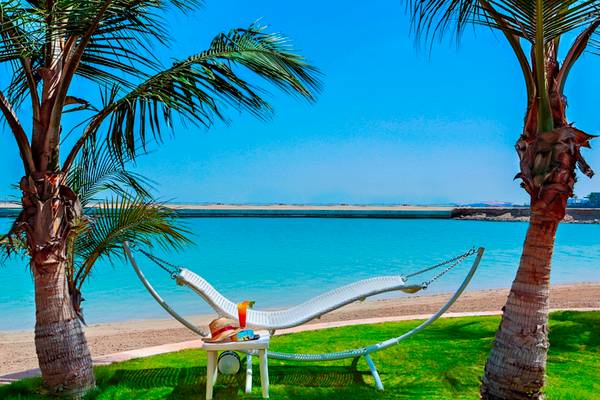 Liegestuhl mit Getraenk am Strand des Al Raha Beach Hotel