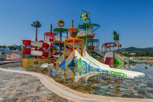 Wasserpark im Rixos Premium Tekirova Hotel mit bunten Rutschen und einem Schwimmbecken.