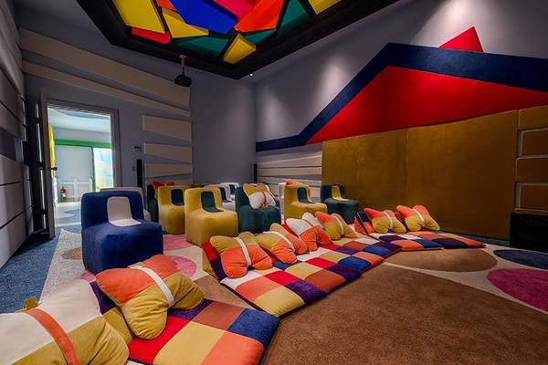Loungebereich im Rixos Premium Tekirova Hotel mit bunten Sofas und Kissen.
